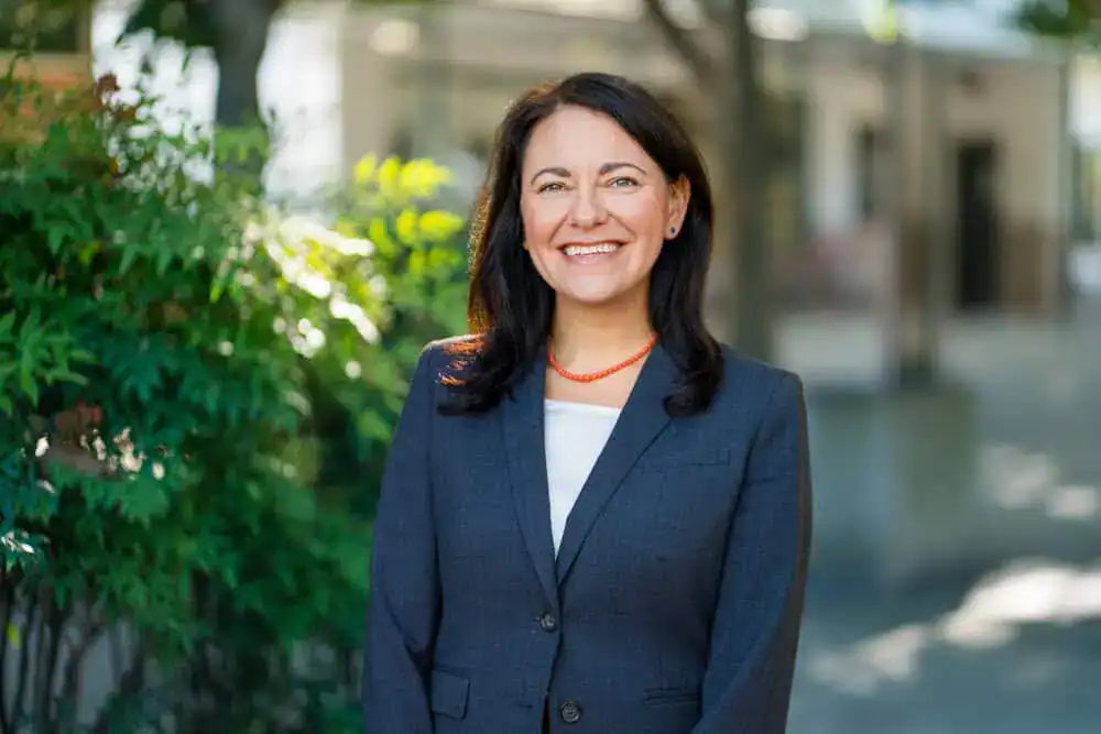 Charmayne Barczewski smiling outdoors in professional attire.